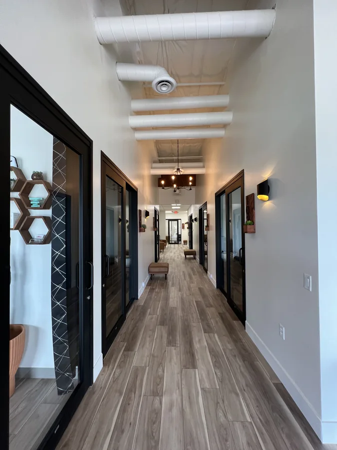 Bloom Hair Salon: Tall finished corridor at Bloom Hair Salon with exposed white ductwork