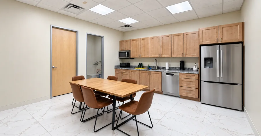Financial Office Build-Out: Finished employee kitchenette and dining table with wood cabinetry and stainless refrigerator