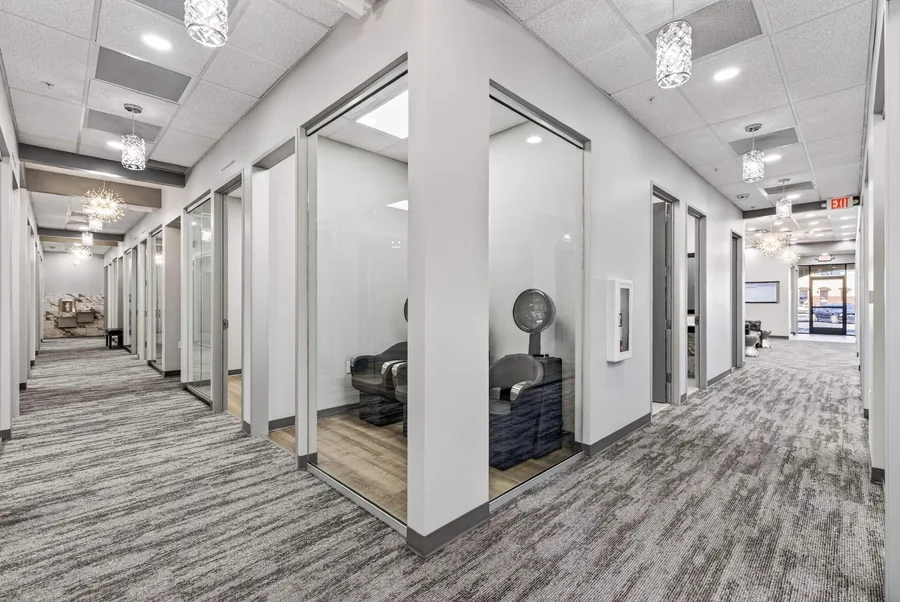 Wild Souls Salon Suites: Glass-front salon suites along a finished corridor at Wild Souls